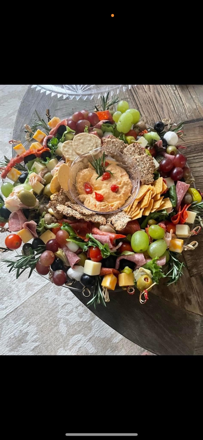 Charcuterie skewers, crackers, grapes, and a central bowl of dip.
